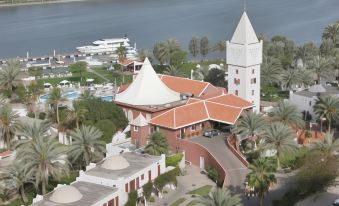 an aerial view of a resort with a large white building , a pool , and a dock at Marbella Resort