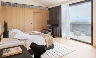 a modern bedroom with a large window , wooden wall paneling , and a bed with white sheets at Briig Boutique Hotel