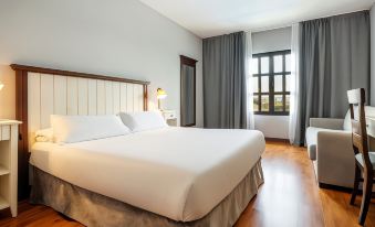 a large white bed with a wooden headboard is in a room with a window and a window shade at Ilunion Hacienda de Mijas