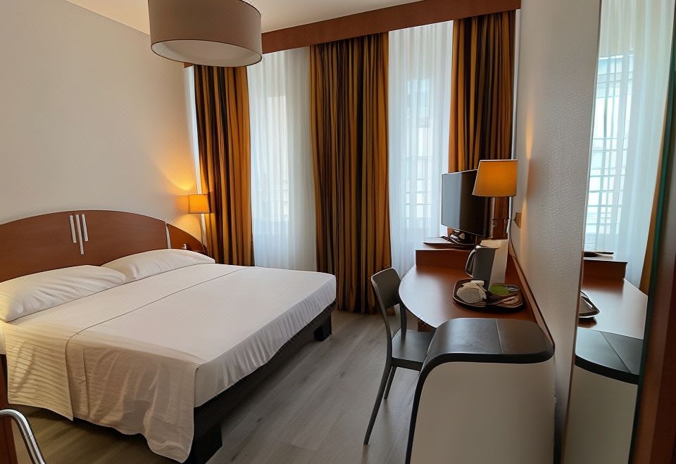 a hotel room with a large bed , a desk , and a tv . the room is well - lit and appears to be clean at Hotel Admiral