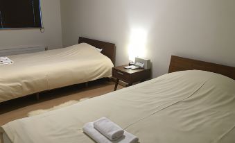 a hotel room with two beds , one on the left and one on the right side of the room at Ume