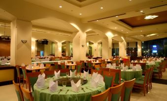 a large dining room with round tables and chairs , all set for a formal dinner at Thumrin Thana Hotel