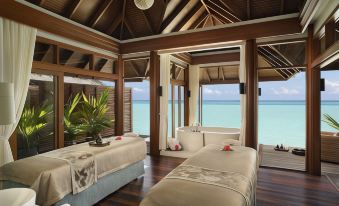 a luxurious beach - side resort with two beds , a bathtub , and a view of the ocean at Anantara Dhigu Maldives
