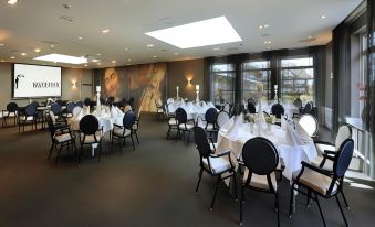 a large , well - lit banquet hall with multiple dining tables set up for a formal event at Van der Valk Hotel Volendam