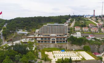 an aerial view of a large , modern building with multiple floors and a courtyard , surrounded by trees and other buildings at Radisson Blu Hotel Trabzon