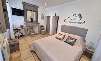 a cozy bedroom with a large bed , a dresser , and a tv . the room has a wooden floor and is decorated with a at La Bastide