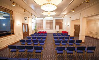 a conference room set up for a meeting , with chairs arranged in rows and a podium in the center at Caledonian Hotel