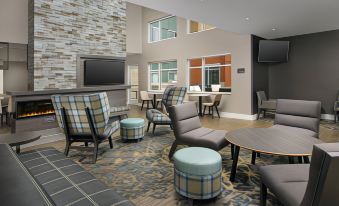 a modern hotel lobby with various seating options , including couches and chairs , as well as a television mounted on the wall at Residence Inn Philadelphia Willow Grove