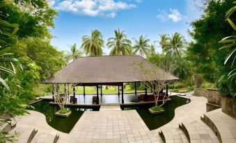 a large wooden gazebo surrounded by lush greenery , with several palm trees in the background at The Farm at San Benito