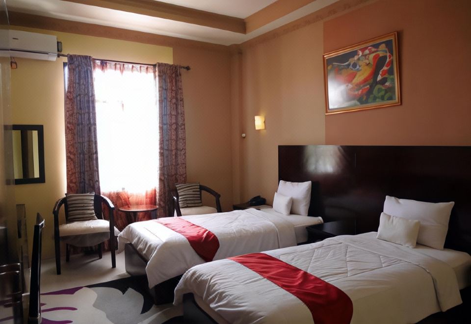 a hotel room with two beds , one on the left and one on the right side of the room at Syafira Hotel Langgur