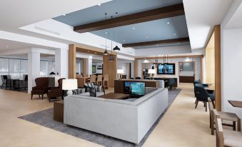 a modern hotel lobby with a large couch , chairs , and tables arranged in a lounge - like setting at Staybridge Suites Pittsburgh Airport