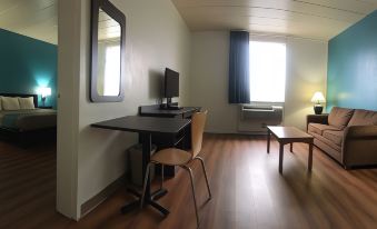 a small room with a desk , a chair , and a tv . also a window in the room at FairBridge Inn Express Melrose Park