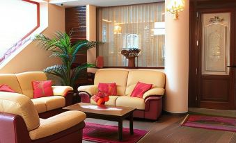 a cozy living room with two couches and a chair , all set against a wall with wooden flooring at Hotel Centrale