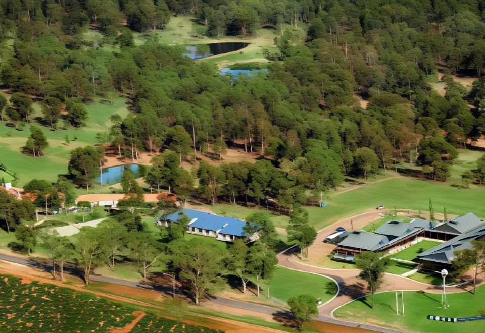 a bird 's eye view of a golf course with trees , water , and buildings in the background at Estate Tuscany