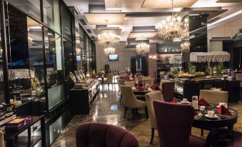 a modern restaurant with marble floors , high ceilings , and a large dining area with numerous tables and chairs at Amaroossa Hotel Bandung Indonesia