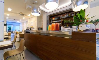 a modern bar with wooden furniture , pendant lights , and a display of colorful items on the counter at Hotel Palace
