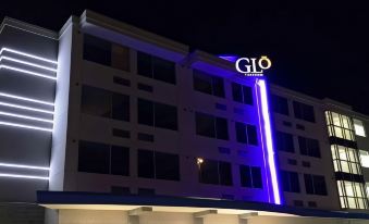 a large hotel building at night , illuminated with blue and white lights , creating a vibrant atmosphere at GLo Best Western Kanata Ottawa West