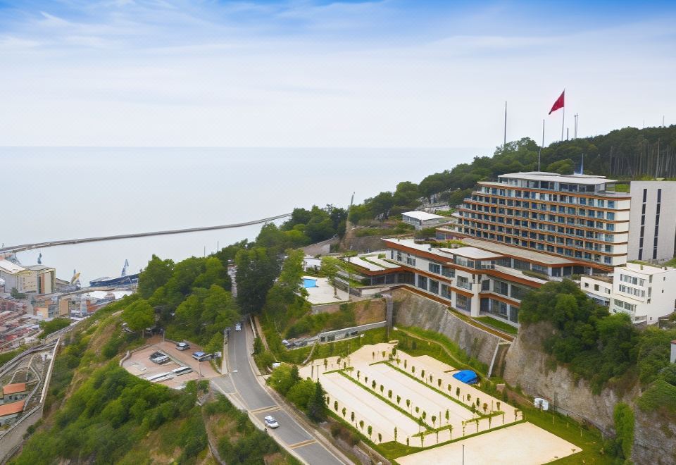 an aerial view of a large hotel complex situated on the edge of a cliff overlooking the ocean at Radisson Blu Hotel Trabzon