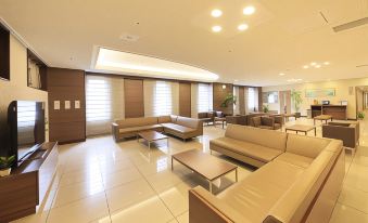 a spacious , well - lit room with multiple couches and chairs arranged in a seating area , creating a comfortable and inviting atmosphere at Daiwa Roynet Hotel Hachinohe