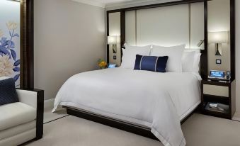 a large , white bed with a black headboard and footboard is situated in a hotel room at Hotel Foret Premier Nampo