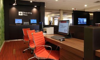 a modern office with multiple chairs arranged around a desk , and a computer monitor on the desk at Courtyard Harlingen