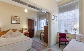 a hotel room with two beds , a desk , and a chair , all in a cozy setting at Victoria House