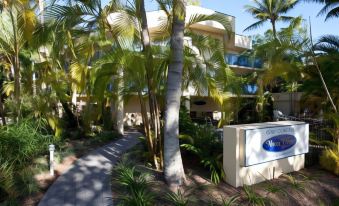 "a lush tropical courtyard with tall palm trees and a sign that reads "" mary poppins hotel ""." at Marina Terraces Port Douglas