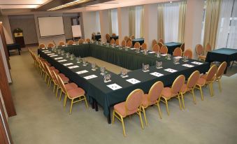 a conference room set up for a meeting , with tables and chairs arranged in a semicircle at Hotel Bellevue