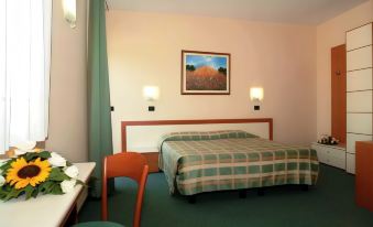 a hotel room with a large bed , a dining table , and a painting on the wall at PRIMAVERA