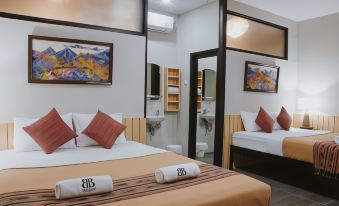 a hotel room with a double bed and a single bed , as well as a bathroom with a sink and toilet at Borobudur Bed & Breakfast