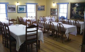 a large dining room with multiple tables and chairs arranged for a group of people at Bestbrook Mountain Farmstay