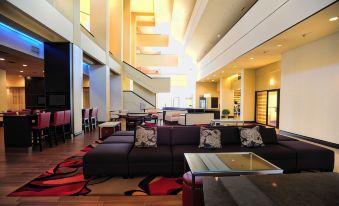 a large hotel lobby with a check - in desk and a seating area , providing a comfortable and inviting atmosphere at Mobile Marriott