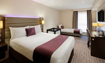 a hotel room with two beds , one of which is a bunk bed , and a window at Premier Inn Bagshot