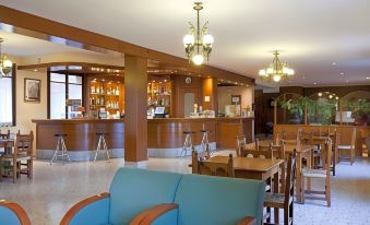 a hotel lobby with a bar , seating area , and tables , creating a comfortable atmosphere for guests at Hotel Mora