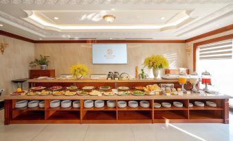 a large dining table with a variety of food items and utensils arranged on it at Riverside Hotel Quang Binh