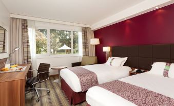 a hotel room with two beds , one on the left side and another on the right side of the room at Holiday Inn Lille - Ouest Englos