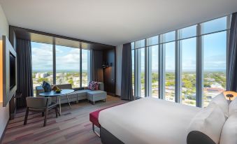 a hotel room with a large bed , a couch , and a window overlooking the ocean at Aloft Perth