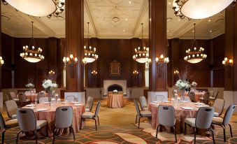 a large , elegant dining room with multiple tables and chairs arranged for a formal event at Kahler Grand Hotel