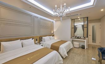 a modern hotel room with two beds , a chandelier , and a mirror , all neatly arranged at Dubai Hotel