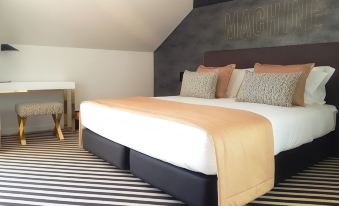 a large bed with a black headboard and white sheets is in a room with black walls at Thomar Boutique Hotel