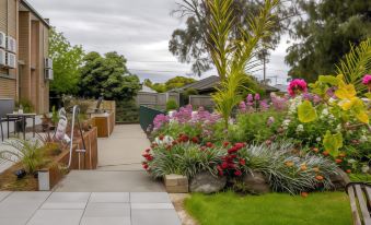 a beautiful garden with a variety of flowers and plants , creating a serene and inviting atmosphere at Parkwood Motel and Apartments