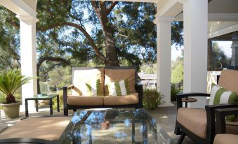 a cozy outdoor living area with a couch , coffee table , and large tree in the background at Arroyo Vista Inn