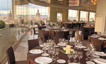 a large dining room with round tables and chairs arranged for a formal event , possibly a wedding reception at Only You Hotel Valencia