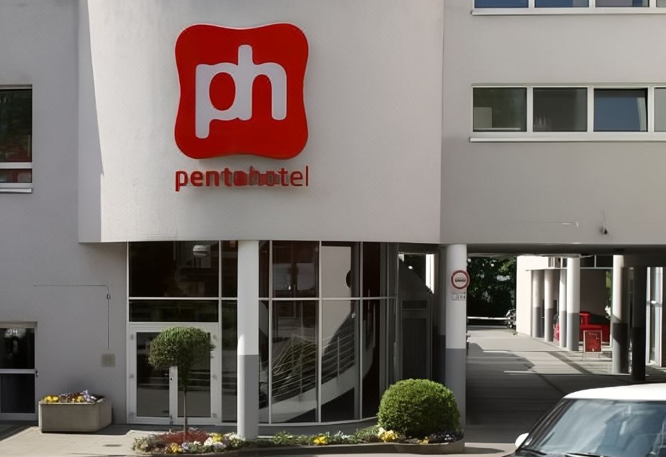 "the exterior of a hotel with a red sign that reads "" penta hotel "" in white letters" at Pentahotel Wiesbaden