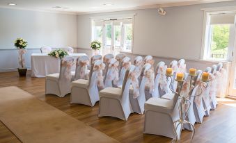 a large room with rows of chairs arranged for a wedding ceremony , possibly a ceremony or reception at Macdonald Hill Valley Hotel Golf & Spa