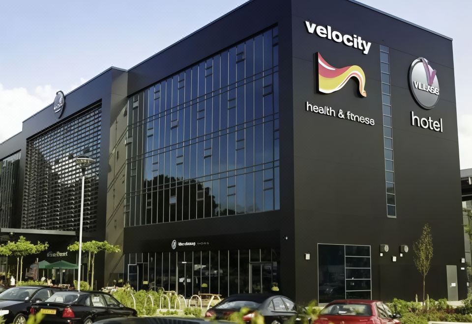 "a modern building with a large black sign that reads "" velocity health & fitness "" prominently displayed on it" at Village Hotel Farnborough