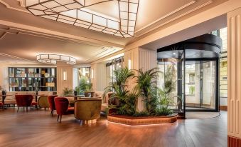 a modern living room with wooden floors , large windows , and multiple potted plants , creating a cozy and inviting atmosphere at Only You Hotel Valencia