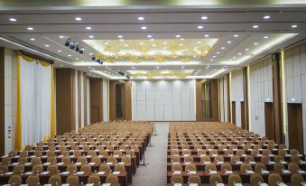 a large conference room with rows of chairs arranged in front of a projector screen at Grand Fortune Hotel Nakhon Si Thammarat