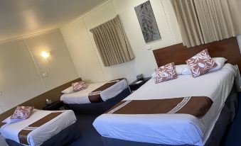 a hotel room with three beds , one on the left , one in the middle , and one on the right at Echuca Motel