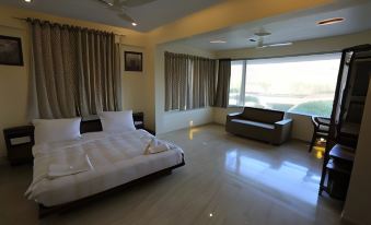 a modern bedroom with a large bed , couch , and windows , giving it a bright and airy atmosphere at River Rock Resort